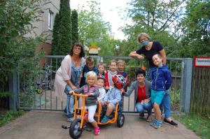 Kinder, 2 Erzeiherinnen und die Radverkehrsbeauftragte bei der Übergabe des Kinderfahrzeugs an die Kita Frechdachs
