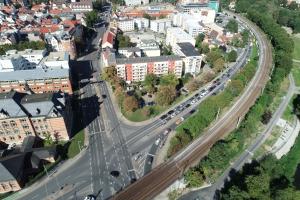 Luftbild von der Kreuzung Stadtrodaer Straße / Am Eisenbahndamm mit Wohnhäusern, Bahnschienen und Bäumen