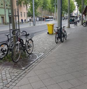 Bild vom Löbdergraben mit Fahrrädern im Vordergrund, dahinter Straßenbahnschienen und Haltestelle