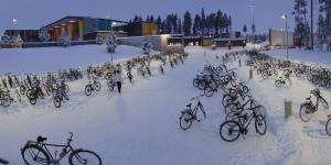 Gebäude und parkende Fahrräder auf einem Platz im Winter mit Schnee