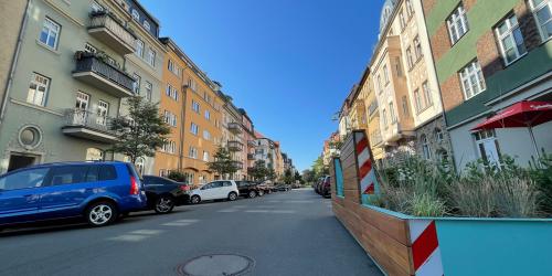 Blicke von der Kreuzung St.-Jacob-Straße in die Sophienstraße, rechts das Parklet, blauer Himmel, Häuserfronten rechts und links, parkende Autos