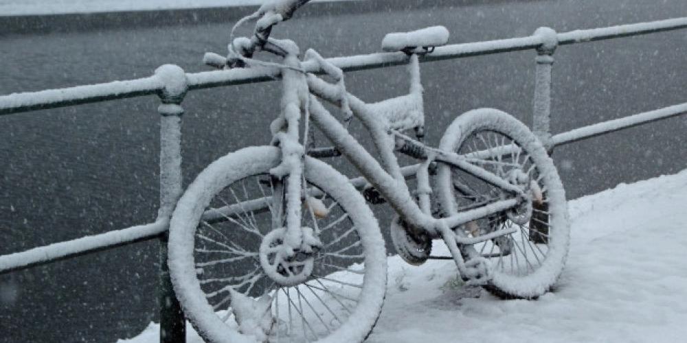 Fahrrad am Zaun im Schnee