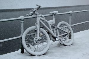 Fahrrad am Zaun im Schnee