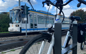 Nahaufnahme eines Fahrrades, im Hintergrund eine Straßenbahn