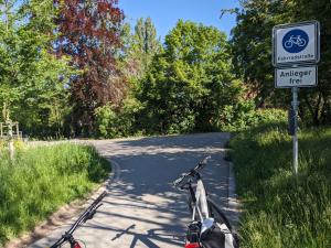 Saaleradweg in Jena zwischen Lobeda West und Gärtnerei Book, Asphaltierter Weg, im Vordergund ein Fahrrad, Beschilderung Fahrradstraße rechts. Im Hintergrund Bäume