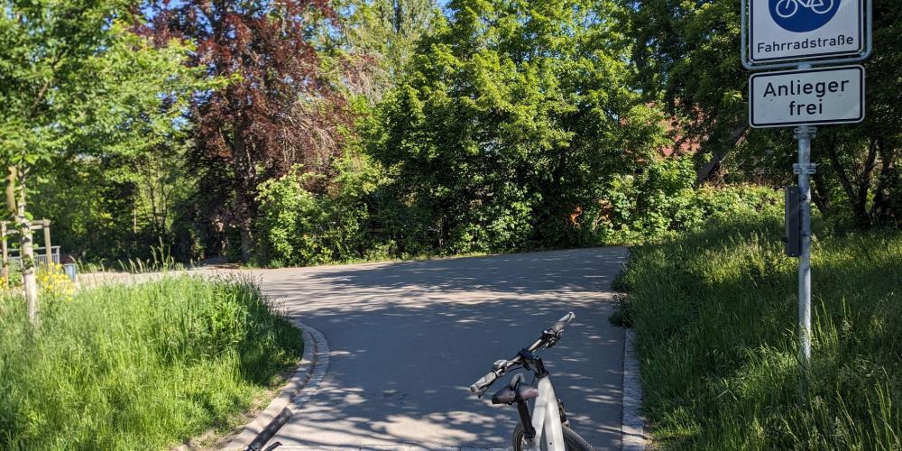 Saaleradweg in Jena zwischen Lobeda West und Gärtnerei Book, Asphaltierter Weg, im Vordergund ein Fahrrad, Beschilderung Fahrradstraße rechts. Im Hintergrund Bäume