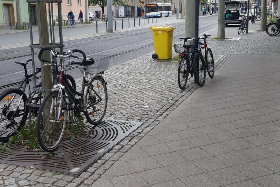 Bild vom Löbdergraben mit Fahrrädern im Vordergrund, dahinter Straßenbahnschienen und Haltestelle
