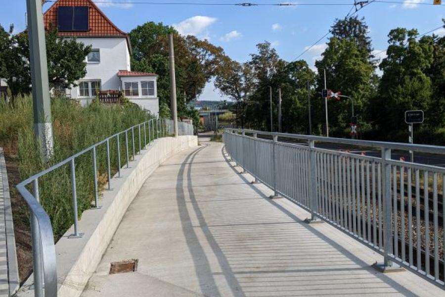 Blick auf den Rad-Gehweg an der Rudolstädter Straße ab Einmündung Hermann-Löns-Straße, blauer Himmel, sonnig, Weg mit Geländer im Vordergrund beginnend