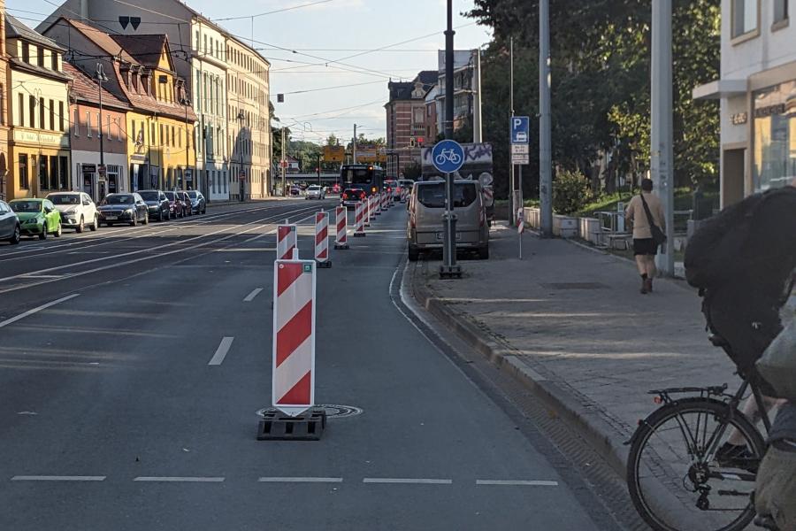 Bild vom Popup-Radweg im Löbdergraben Jena, abgetrennt durch rot-weiße Baken